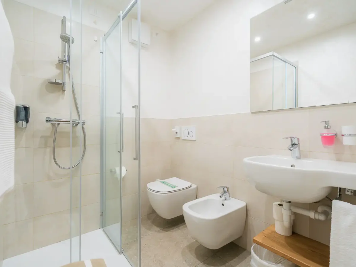 Bagno moderno con cabina doccia, lavabo, bidet e WC.