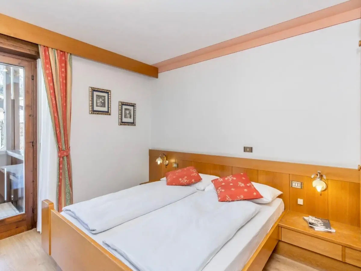 Camera da letto accogliente con letto matrimoniale e arredi in legno.