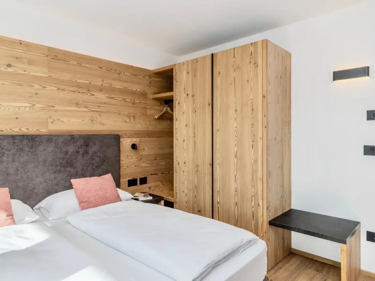 Camera da letto moderna con pareti e mobili in legno chiaro.