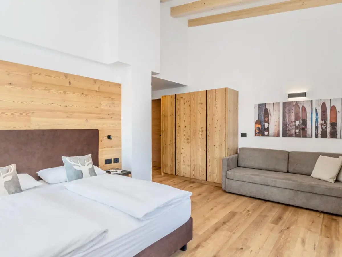 Camera da letto moderna con arredamento in legno e decorazioni a tema sciistico.