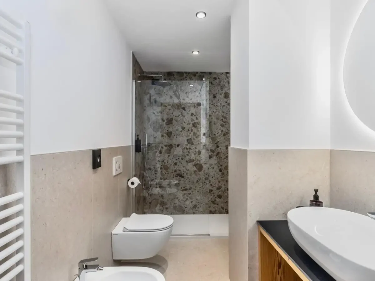 Bagno moderno con doccia in vetro e lavabo elegante.