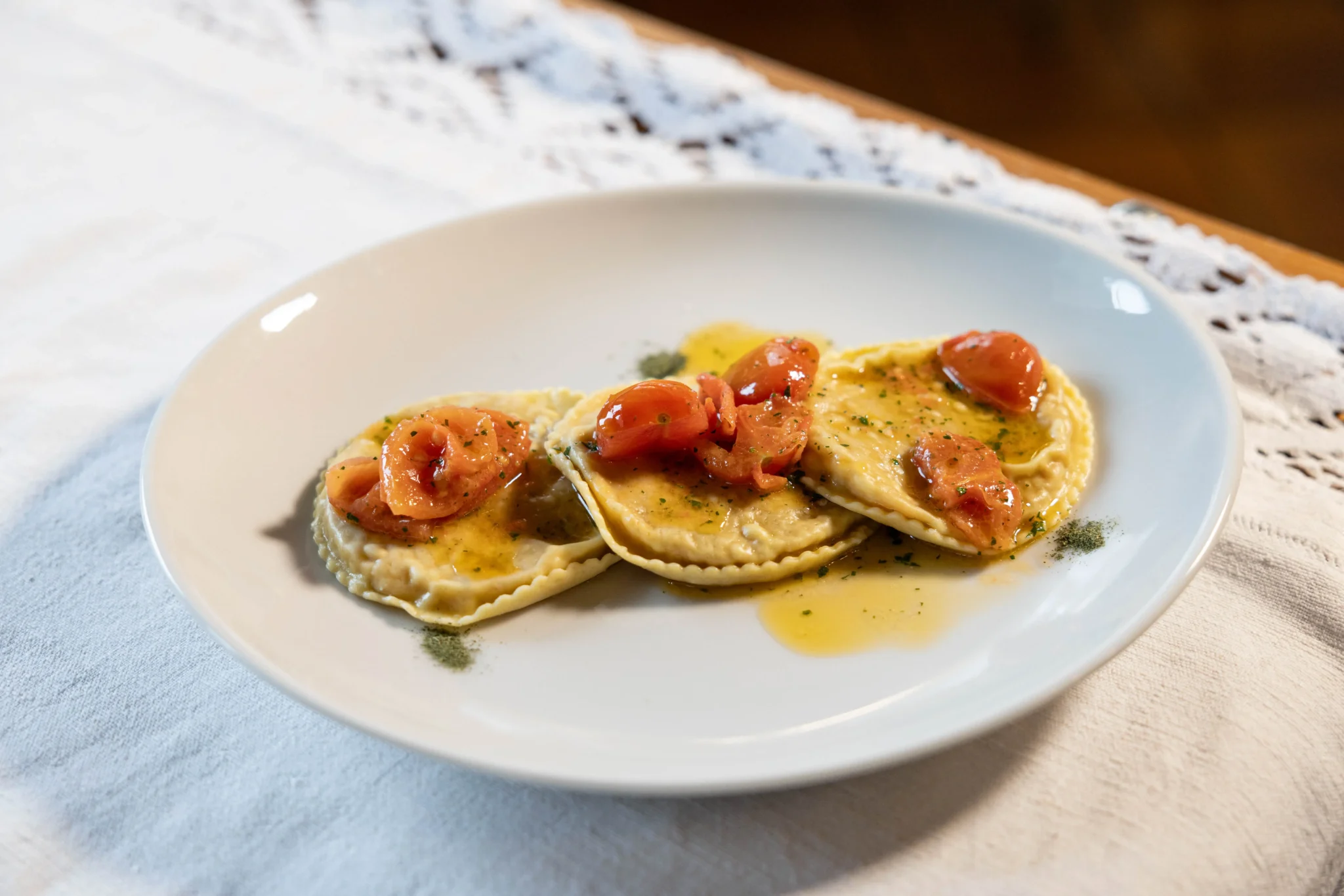 Piatto di ravioli con pomodori e salsa.