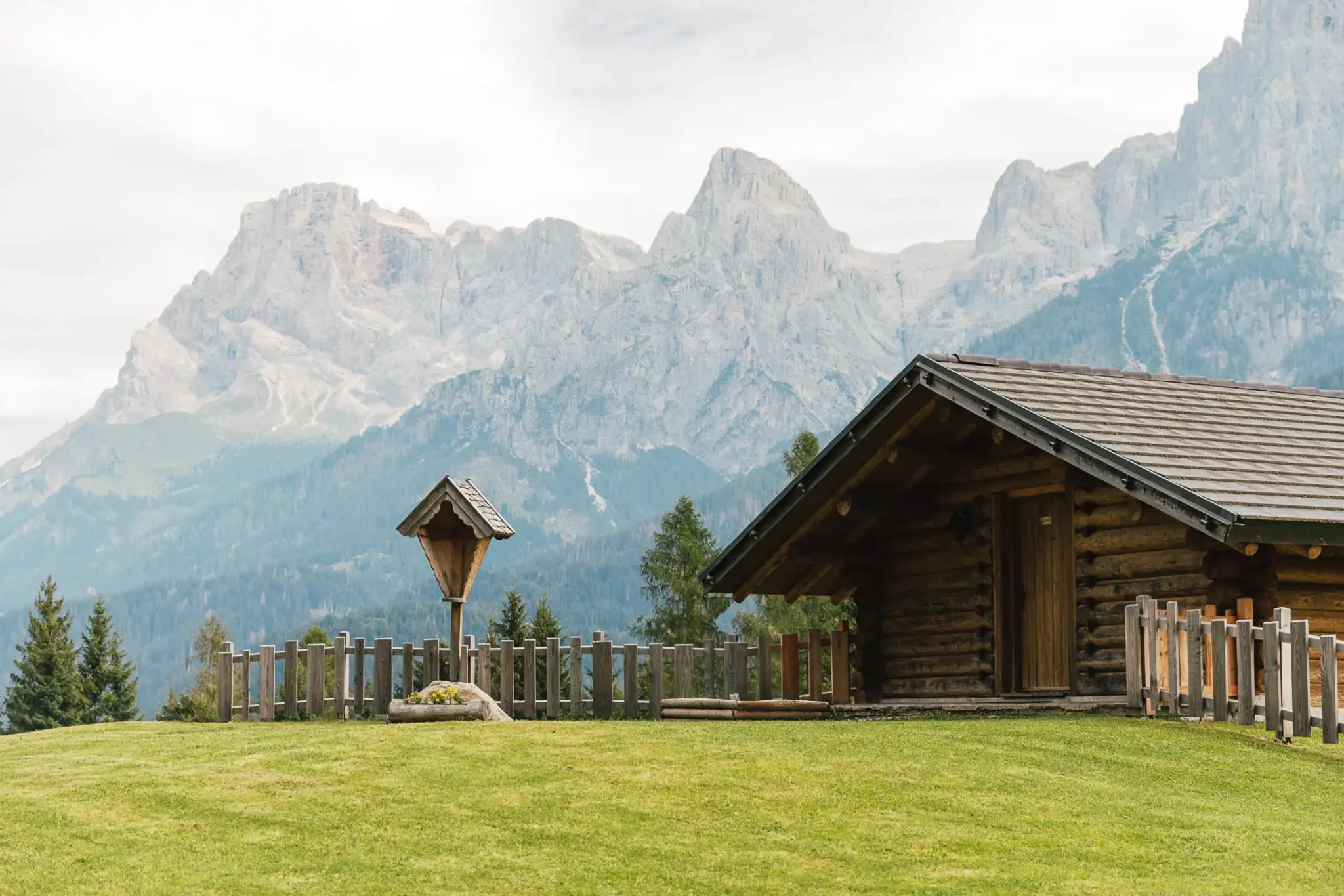 Chalet di legno con montagna sullo sfondo.